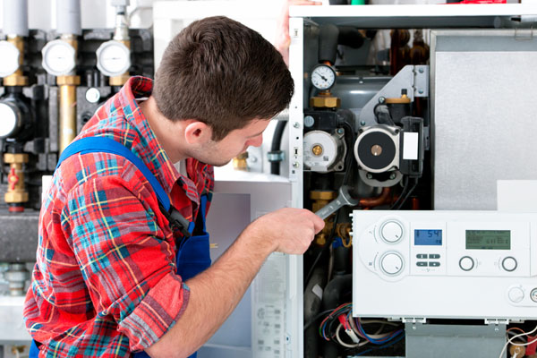 HVAC technician inspecting and repairing boiler controls in Laveen