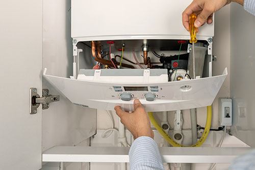 HVAC technician repairing an indoor boiler in Laveen