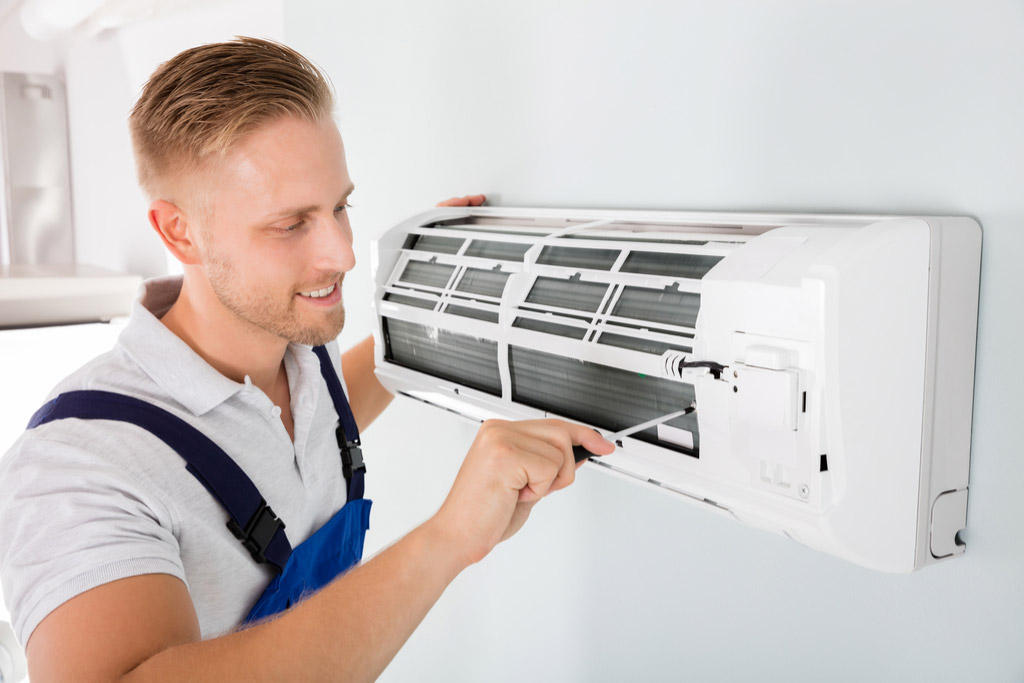 HVAC technician performing ductless air conditioning maintenance in Laveen