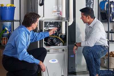 65df8c11f3e4c468cbd351a5_furnace repair vs replacement – Copy HVAC technician explaining furnace repair and maintenance to a homeowner in Laveen, AZ