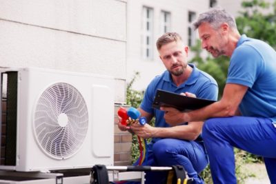 ac-installation-in-claremont-ca HVAC technicians reviewing an outdoor air conditioning unit in Laveen, AZ